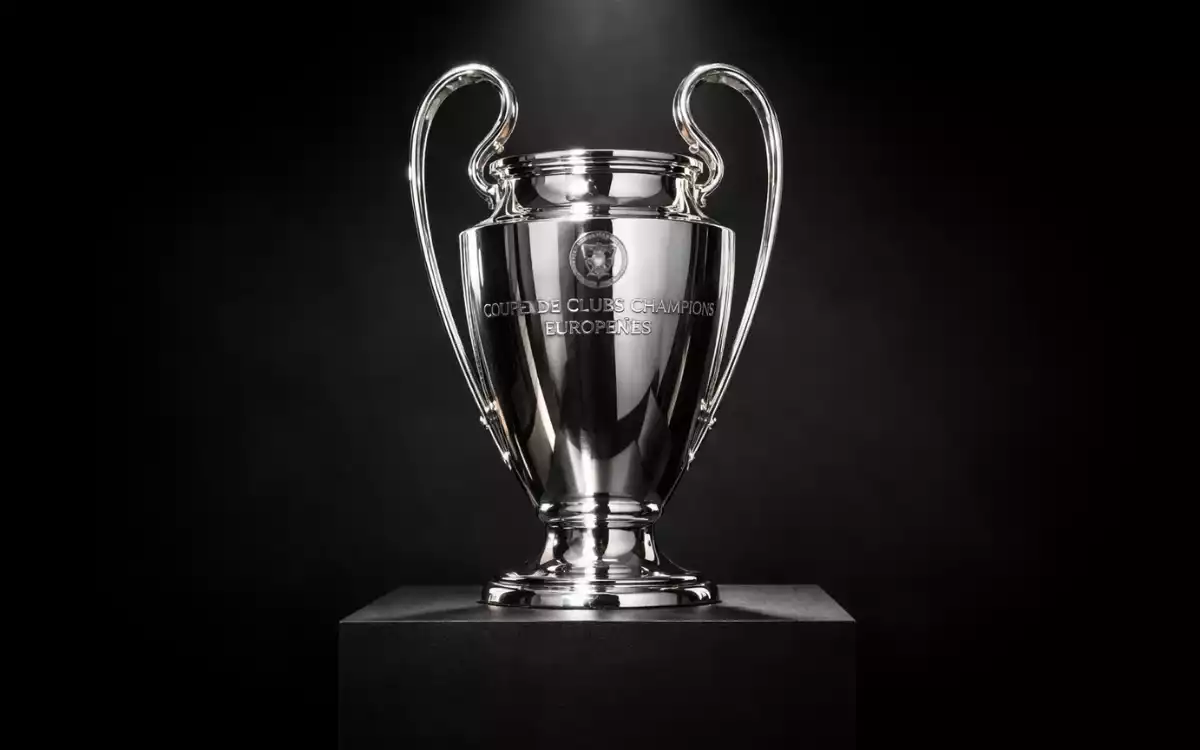 Troph&eacute;e de la Ligue des Champions expos&eacute; sous une lumi&egrave;re dramatique &eacute;voquant le prestige de la comp&eacute;tition
